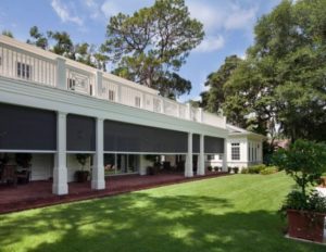 a large white building with columns and a lawn