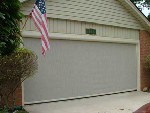 A roll-down garage screen installed, offering easy access and protection from insects while maintaining an open, airy feel in the garage when rolled down